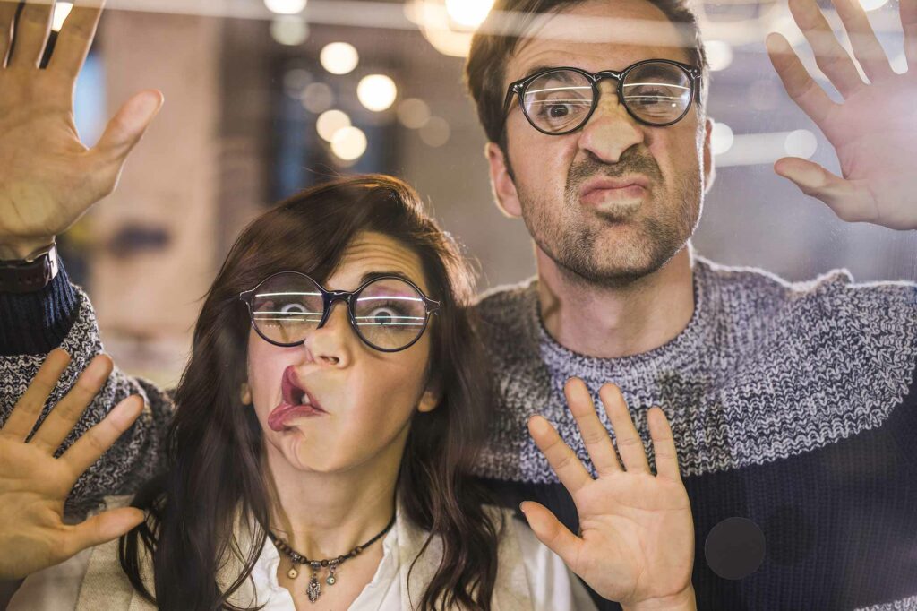Un homme et une femme derrière une porte vitrée