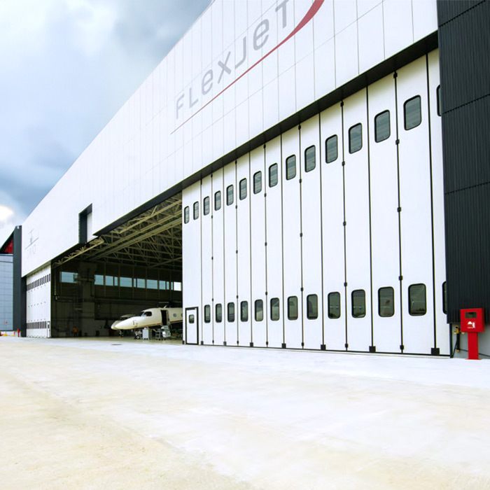 Portalp porte industrielle pliante grande dimension Moreschi blanche secteur transport aérien